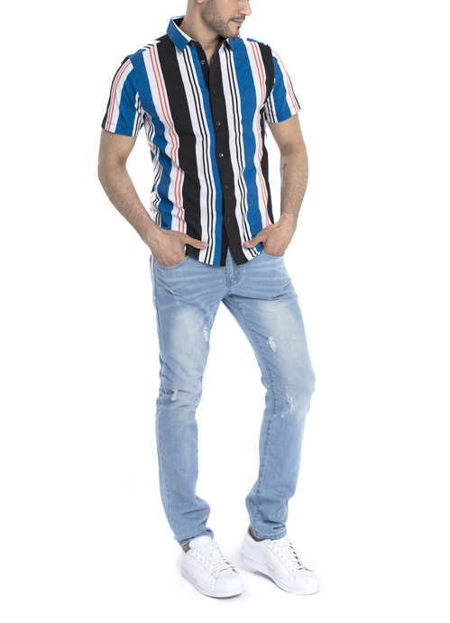 Model wearing balck white and blue stripe shirt with blue jeans.