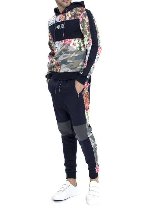 Model wearing floral design hoodie with black jogger pants.