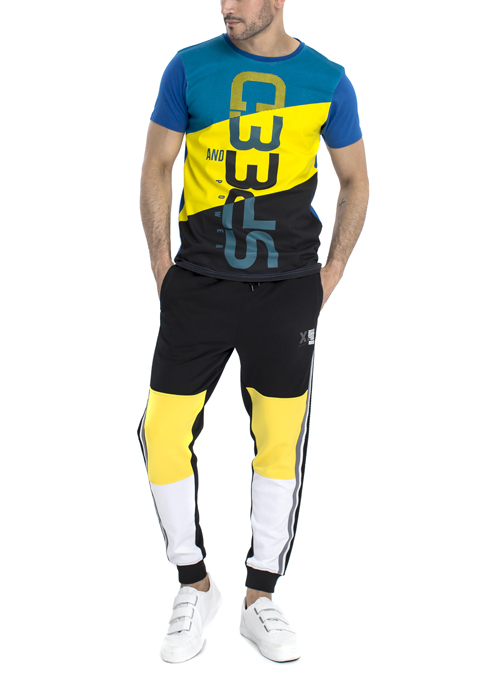 Model wearing blue white and black shirt with black yellow white jogger pants.