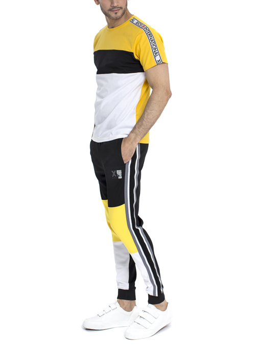 Model wearing yellow and white horizontal stripe shirt with black yellow white jogger pants.