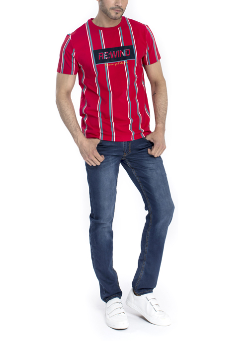 Model wearing red design shirt with blue jeans.