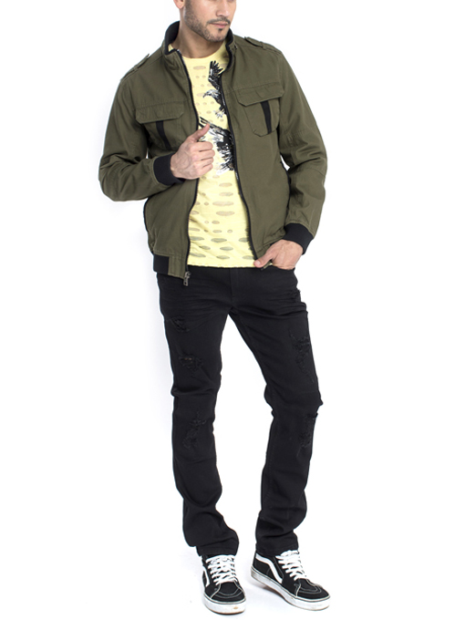 Model wearing green jacket and light yellow with eagle printed shirt with black pants.