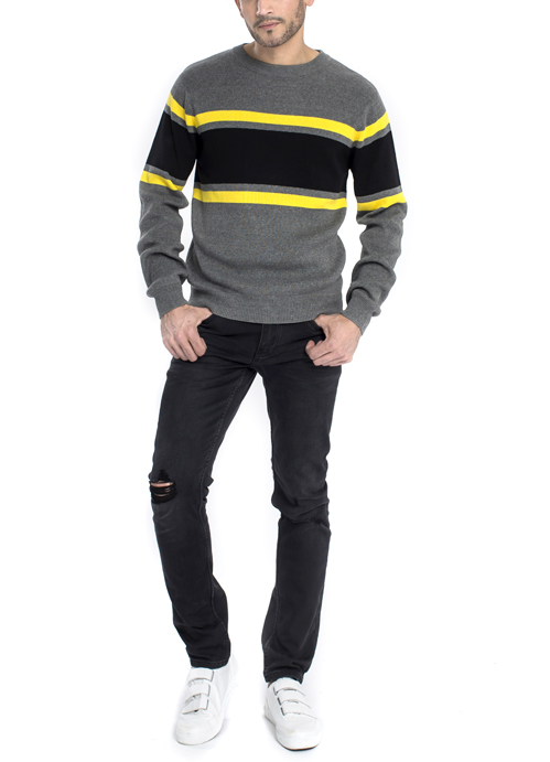 Model wearing grey and yellow horizontal stripe sweater with black jeans.