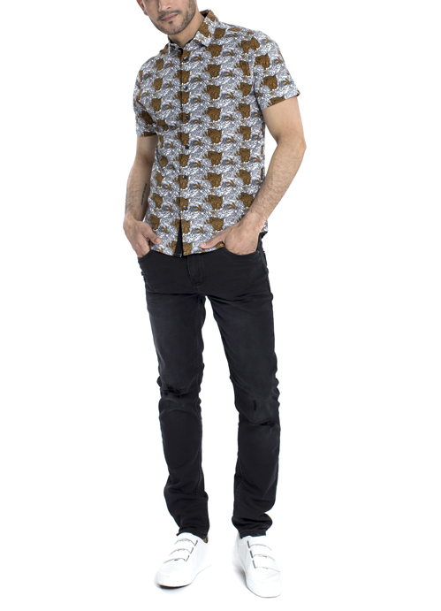 Model wearing brown dotted shirt with black pants.