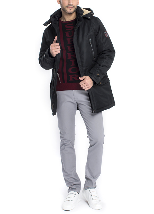 Model wearing long black jacket with grey pants.