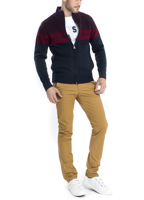 Model wearing red and blue zipped pullover with orange chino pants.