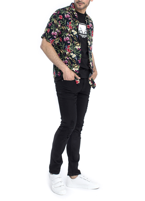 Model wearing flower design shirt with black pants.