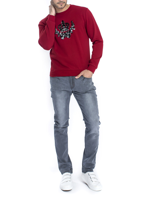 Model wearing red long sleeve pullover with grey jeans.