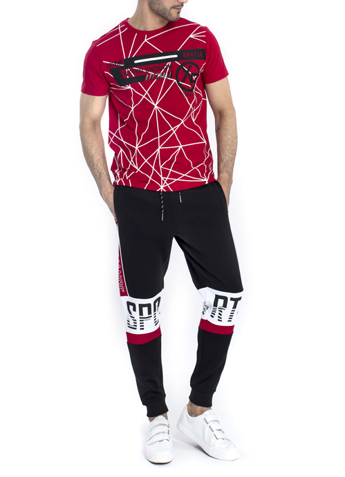 Model wearing red design shirt with black jogger pants.