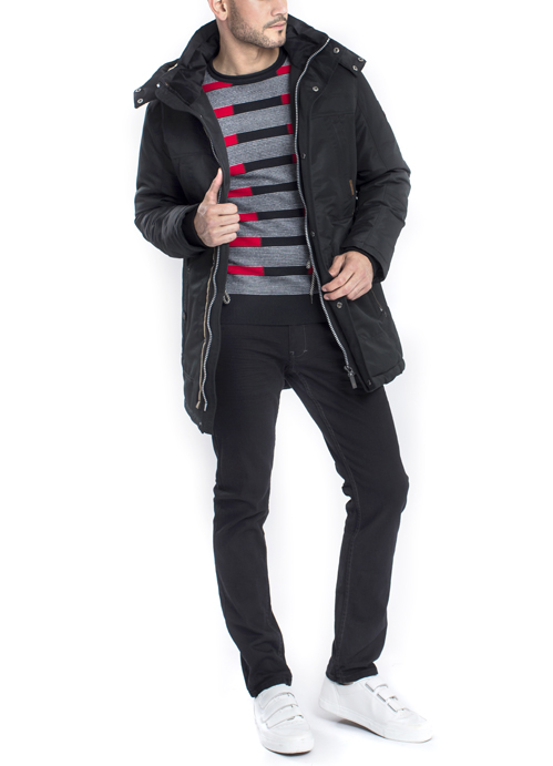 Model wearing black long jacket with red and black horizontal stripe long sleeve shirt with black pants.