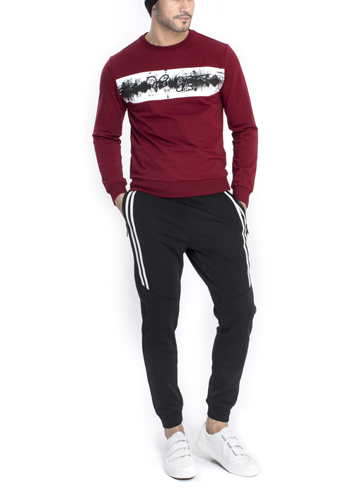 Model wearing long red sleeve shirt with black jogger pants.