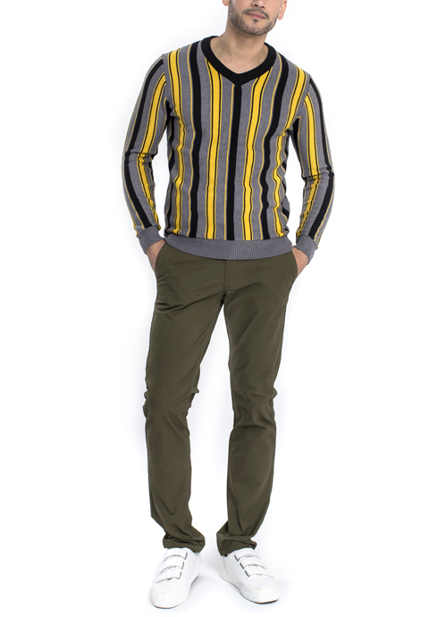 Model wearing black grey and yellow vertical stripe long sleeve shirt with green chino pants.