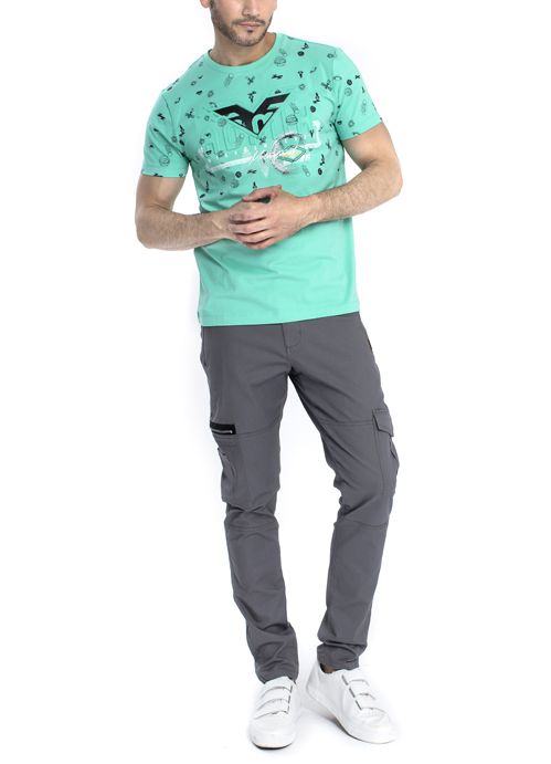 Model wearing teal design shirt with grey pants.